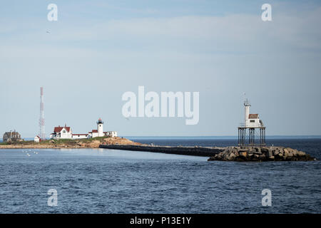 Guardando attraverso l'acqua alla punta orientale faro dal porto di Gloucester, Massachusetts. Foto Stock