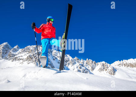 Giovane sciatore felice pronto per sciare sulla cima delle Alpi. Foto Stock