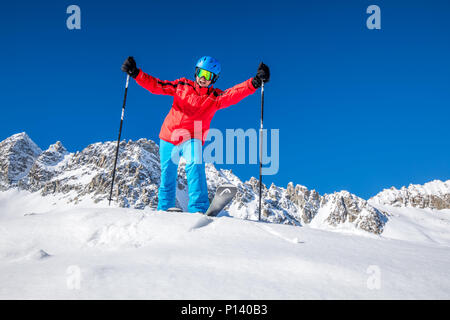 Giovane sciatore felice pronto per sciare sulla cima delle Alpi. Foto Stock