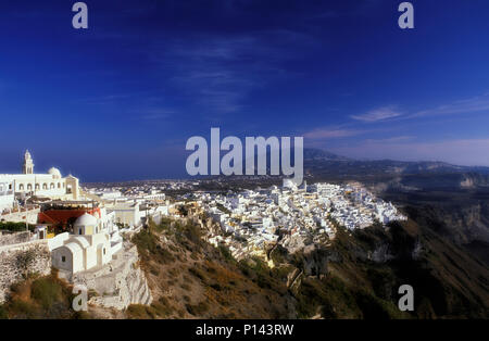 Isola greca di Thira (Santorini), vista delle scogliere, guardando a sud, che mostra la città di Thira lungo la scogliera di bordo con spia tardiva, Grecia Foto Stock