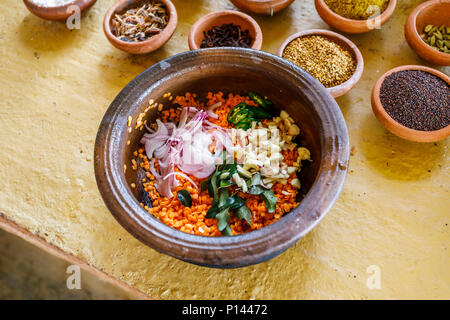 Ciotola di ingredienti per dahl ad una tradizionale ricetta locale: lenticchie, cipolle, aglio e foglie. Horagampita distretto, vicino a Galle, Sri Lanka Foto Stock