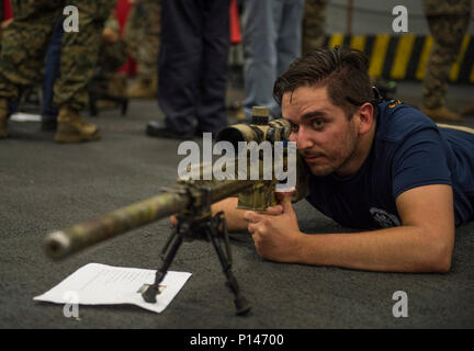 OCEAN (6 maggio 2017) Mitchell valzer, fratello di Hospital Corpsman 3rd Class Mike valzer, guarda attraverso il campo di applicazione di un M110 Semi-Automatic sistema sniper rifle a bordo dell'assalto anfibio nave USS Makin Island (LHD 8). Tiger Cruise ammessi più di 160 amici e membri della famiglia di intraprendere Makin Island a sperimentare STATI UNITI La marina degli Stati Uniti e Marine Corps vita in mare durante la nave il viaggio di ritorno a San Diego dopo sette mesi di distribuzione per gli Stati Uniti 3rd, quinto e settimo aree della flotta di funzionamento. Foto Stock