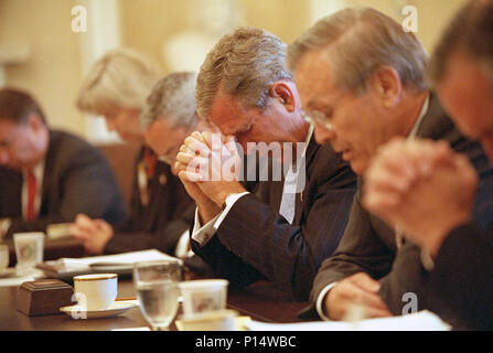 Led in preghiera dal Segretario della Difesa Donald Rumsfeld, destra, Presidente George W Bush si unisce il suo gabinetto come si piegano i loro capi Venerdì, Settembre 14, 2001, prima di iniziare il loro incontro nel Cabinet Room della Casa Bianca. Foto di Eric Draper Foto Stock