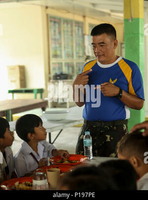 Philippine Air Force 1 Lt. Romero Julimar parla con studenti provenienti da Malabanias scuola integrata in Pampanga, Angeles City, Filippine, 6 ott. 2016. Stati Uniti e Philippine Marines e marinai sono la riparazione di scuole locali come parte dei filippini di sbarco (esercizio PHIBLEX) 33. PHIBLEX è un annuale U.S.-militari filippini esercizio bilaterale che combina capacità anfibie e live-formazione antincendio con umanitario assistenza civica gli sforzi volti a rafforzare l'interoperabilità e i rapporti di lavoro. Romero, da Ilocos Sur, Filippini è il direttore di civili delle operazioni militari Foto Stock