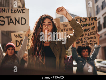 La donna a capo di un gruppo di manifestanti sulla strada. Un gruppo di donne che protestavano per la parità di opportunità e di empowerment delle donne. Foto Stock