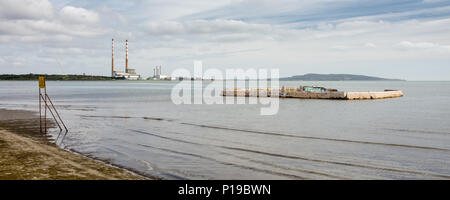 La abbandonata e in disuso lido in calcestruzzo su Sandymount Stand Beach nella Baia di Dublino, con il punto di riferimento twin camini di Poolbeg Power Station in distan Foto Stock