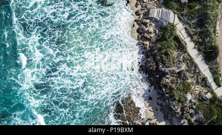 Vista aerea surf Oceano Mare di acqua di lavaggio sul litorale sabbioso con scale che conducono alla spiaggia Foto Stock