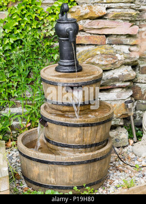 Giardino caratteristica dell'acqua disposta come tre barili con pompa in alto Foto Stock