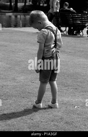 Giovane ragazzo in piedi da solo in shorts foto in bianco e nero Foto Stock