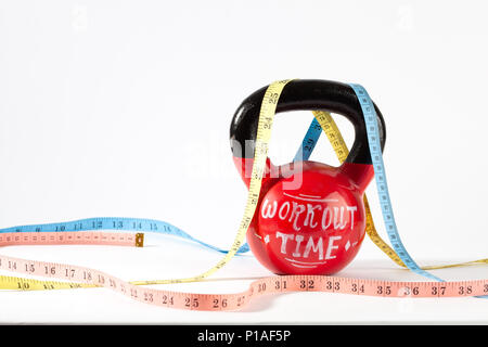 Bollitore rosso campana con nastro di misurazione e il tempo di allenamento lettering isolato su sfondo bianco con copia spazio - uno stile di vita sano e perdita di peso concep Foto Stock