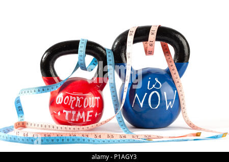 Il rosso e il blu kettlebells con tempo di allenamento è ora di scritte e nastro di misurazione isolata su sfondo bianco - uno stile di vita sano e perdita di peso concep Foto Stock