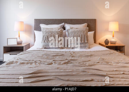 Cuscini decorativi su disposizione del letto con camera da letto lampade e  comodini Foto stock - Alamy