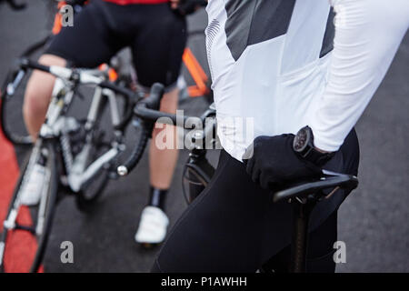 Close up ciclista maschio in appoggio sulla bicicletta Foto Stock