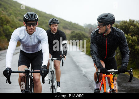 I ciclisti di sesso maschile ciclismo su strada bagnata Foto Stock