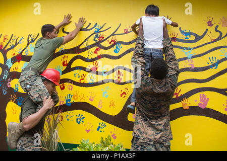 Stati Uniti Marines con Bravo Company, 9 Supporto tecnico di battaglione, 3d Marine Logistics Group, III Marine forza expeditionary e uno studente del Palawig Scuola elementare posto mano più thier stampe su una parete che è stata restaurata durante il Philippine Sbarco esercizio 33 (PHIBLEX) in Cagayan Valley, Filippine, 10 ottobre, 2016. PHIBLEX è un annuale U.S.-militari filippini esercizio bilaterale che combina capacità anfibie e live-formazione antincendio con umanitario assistenza civica gli sforzi volti a rafforzare l'interoperabilità e i rapporti di lavoro. (U.S. Marine Corps photo by MCIPAC combattere Ca Foto Stock