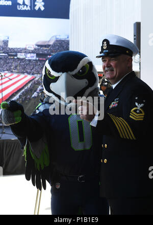 161011-N-WX604-091 SEATTLE (ott. 11, 2016) Master Chief Petty Officer ricca Magee, di stanza a bordo della USS città di Corpus Christi (SSN 705), pone con Blitz, il Seattle Seahawks mascot, durante il quinto annuale USAA Modifica del comando cerimonia al campo CenturyLink. Questo anno il Seattle Seahawks e USAA ha presentato la marina con il dodicesimo uomo bandiera di essere il team di onorato servizio per la stagione. (U.S. Navy foto di Sottufficiali di terza classe Giuseppe Montemarano/rilasciato) Foto Stock