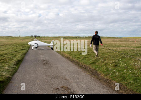 161012-N-JE250-050 BENBECULA, Regno Unito (ott. 12, 2016) Markus Hucik, una S-100 CamCopter drone operatore di manutenzione, porta un cavo di alimentazione da inserire in un S-100 a Benbecula Rangehead. Più di 40 partecipanti internazionali da altre marine, industria, università e laboratori di ricerca sono in Scozia di conduzione del primo-mai guerriero senza equipaggio, di ricerca e di esercizio progettata per testare e dimostrare la più recente di autonoma tecnologie navali e contemporaneamente il rafforzamento di interoperabilità internazionale. Il guerriero senza equipaggio è parte del giunto del Guerriero, un semia Foto Stock