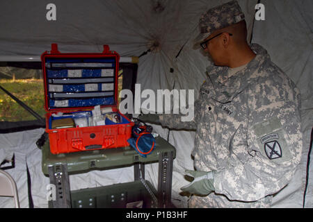 Spc. Lyndrath Martin, una specialista del settore sanitario con il decimo combattere la Brigata Aerea, organizza le apparecchiature all'interno il medic tenda a Fort Drum, NY, il 15 ottobre. Martin sarà contribuendo a organizzare e addestrare soldati su argomenti come il modo corretto di applicare un laccio emostatico, portano una lettiera e cure mediche di base in tutta la montagna annuale di formazione di picco esercizio. (U.S. Esercito foto di Spc. Thomas Scaggs) Foto luce e colore bilanciato in Photoshop 161015-A-TZ475-036 Foto Stock