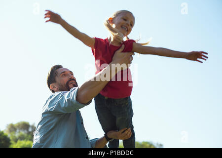 Caring daddy giocando con sua figlia all'aperto Foto Stock