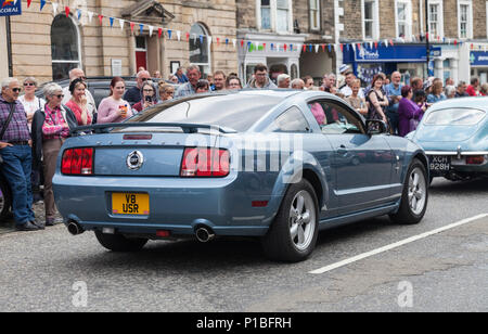Un blu Ford Mustang auto in parata di vetture attraverso Barnard Castle,l'Inghilterra,UK Foto Stock