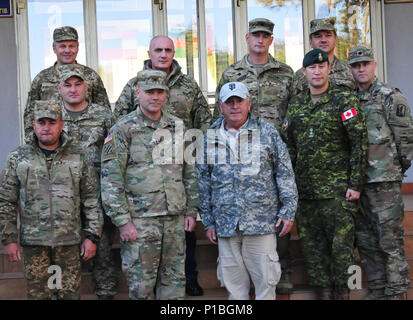 YAVORIV, Ucraina- Esercito generale in pensione John Abizaid, advisor in Ucraina il Ministro della Difesa, posa per una foto con la multinazionale partner durante una visita per il mantenimento della pace internazionale e Centro sicurezza, Ott 14. Abizaid è stato recentemente nominato advisor ad ucraino il Ministro della Difesa di Stepan Poltorak dal Segretario della Difesa Carter di cenere. JMTG-U ha la missione è parte del costante impegno di contribuire all'Ucraina a lungo termine di riforma militare e professionalità e per aiutare a migliorare la interna del paese le capacità di difesa e di capacità di formazione. (Foto dal personale dell'esercito Sgt. Elizabeth Tarr) Foto Stock