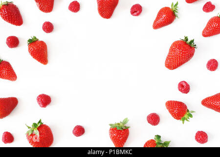 Frutta estiva pattern. Sana rosso fresco fragole e lamponi, isolato sul tavolo bianco sullo sfondo. Modello alimentare. Composizione circolare. Appartamento laico, vista dall'alto. Elegante stock photo. Foto Stock