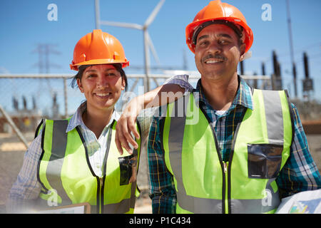 Ritratto fiducioso e sorridente ingegneri in impianto di alimentazione Foto Stock