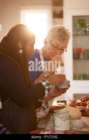 Le donne anziane amici odore di formaggio fresco in pizza Cooking class Foto Stock