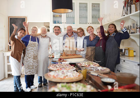Ritratto fiducioso active senior amici e chef tenendo la pizza Cooking class Foto Stock