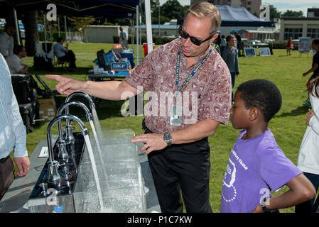 161012-N-YD204-005 Atsugi, Giappone (ott. 12, 2016) Naval Facilities Engineering Command (NAVFAC) Estremo Oriente il distacco di Atsugi Vice Opere Pubbliche Officer Gary Gentz dimostra un consumo di acqua presentano per uno studente da Shirley elementare Lanham durante una energia fiera alla Naval Air Facility di Atsugi. NAVFAC tenutasi nella fiera in riconoscimento della conservazione di energia al mese. (U.S. Navy foto di Sottufficiali di terza classe Matteo C. Duncker/rilasciato) Foto Stock