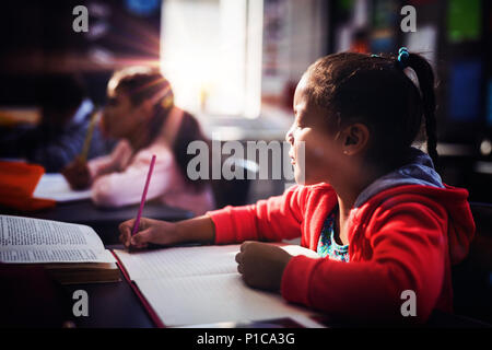 Attento schoolgirl facendo i suoi compiti in classe Foto Stock