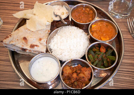 Indiano settentrionale grand thali pasto incluso papadums burro formaggio paneer masala raita naan riso e dessert pasto vegetariano made in England Regno Unito Foto Stock