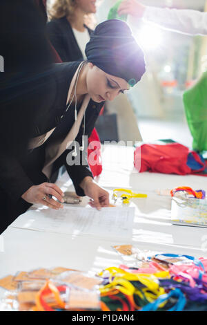 Imprenditrice indossa velo il check in durante la conferenza per la tabella di registrazione Foto Stock