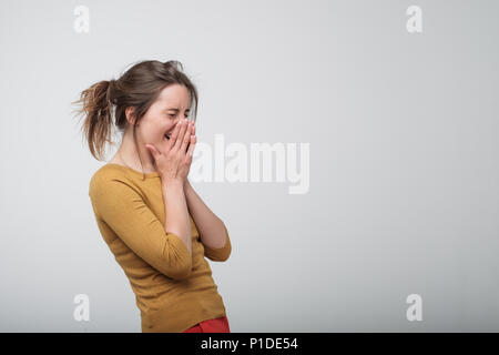 Felice allegro giovane donna ridendo e chiudendo le mani. Foto Stock