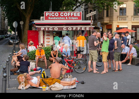 Persone che acquistano bevande presso un chiosco ristoro e di bere in strada a Colonia Foto Stock