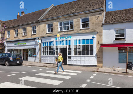 Sequenza 3 di 5, una donna attraversa le strisce pedonali in Malmesbury High Street al di fuori di Barclays Bank. Come ella velocità fino vi è il motion blur, Wiltshire, Regno Unito Foto Stock