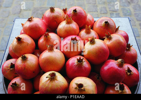 Piatto di rosa e rosso melagrane per la vendita su un mercato della frutta Foto Stock