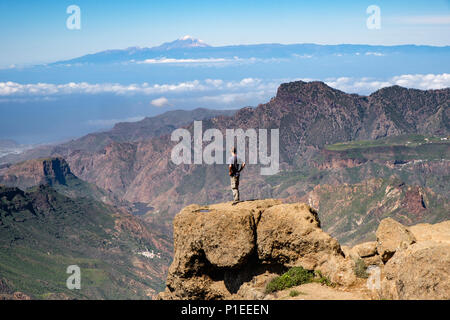 L'uomo guarda da Roque Nublo oltre il paese di montagna di Gran Canaria verso il vulcano Teide, Gran Canaria Isole Canarie Spagna Foto Stock