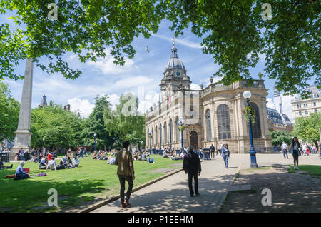 Il terreno attorno a San Filippo la cattedrale nel centro di Birmingham, UK con gente seduta sul prato sotto il sole Foto Stock