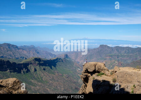 L'uomo guarda da Roque Nublo oltre il paese di montagna di Gran Canaria con il vulcano Teide All'orizzonte, Gran Canaria Isole Canarie Spagna Foto Stock