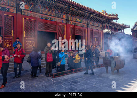 Pechino, Cina - 10 Marzo 2016: adoratori tenere i bastoncini di incenso e di pregare presso Yonghegong il Tempio dei Lama a Pechino in Cina. Foto Stock