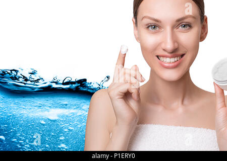 Bellissimo modello Spa donna con spruzzi di acqua. Bella ragazza sorridente sotto la pioggia di acqua con la pelle fresca su sfondo blu. Cura della pelle, pulisce Foto Stock