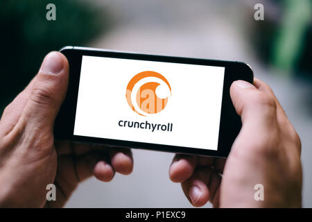 Primo piano della schermata dello smartphone con il bianco CRUNCHYROLL APP LOGO e icona Foto Stock