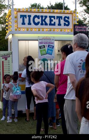 Wyndmoor, PA, Stati Uniti d'America - 8 Giugno 2018: partecipanti attendere in linea in un ticket booth mentre due ragazze verificare se essi soddisfano i requisiti di altezza per passeggiate al Foto Stock