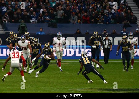 Los Angeles Rams wide receiver Kenny Britt, 18, schivato New York Giants giocatori difensiva durante la seconda NFL serie internazionale del gioco del calcio a Twickenham Stadium di Londra, Inghilterra, Ott. 23. 48Th Fighter Wing aviatori presentato la bandiera durante la riproduzione di un inno nazionale prima del calcio d'inizio. I Giganti sconfitti i montoni 17-10. (U.S. Air Force foto/Airman 1. Classe Eli Chevalier) Foto Stock