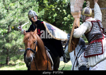 Nis, Serbia - Giugno 10, 2018: due cavaliere medievale combattimenti con la spada su cavalli in natura. Medioevo il concetto di battaglia Foto Stock