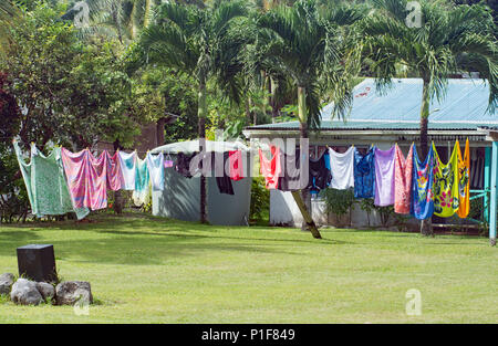 Lavaggio colorati appesi ad asciugare su una lunga linea di abbigliamento in Aitutaki Foto Stock