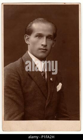 LIBEREC (REICHENBERG), LA REPUBBLICA CECOSLOVACCA - CIRCA 1920s: Foto d'epoca mostra che il giovane indossa una giacca. Antico ritratto in bianco e nero da studio. 1920s. Foto Stock