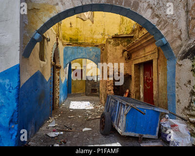 Urban grunge con sfondo blu e giallo le pareti e gli archi di case della medina portoghese di El Jadida, Marocco. Foto Stock