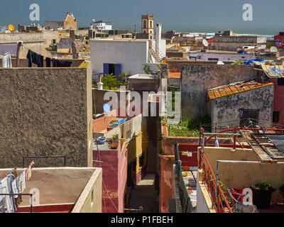 Tetti di edifici antichi della medina di El Jadida città: alte mura, corda con abiti appesi, cielo blu, Marocco. Foto Stock